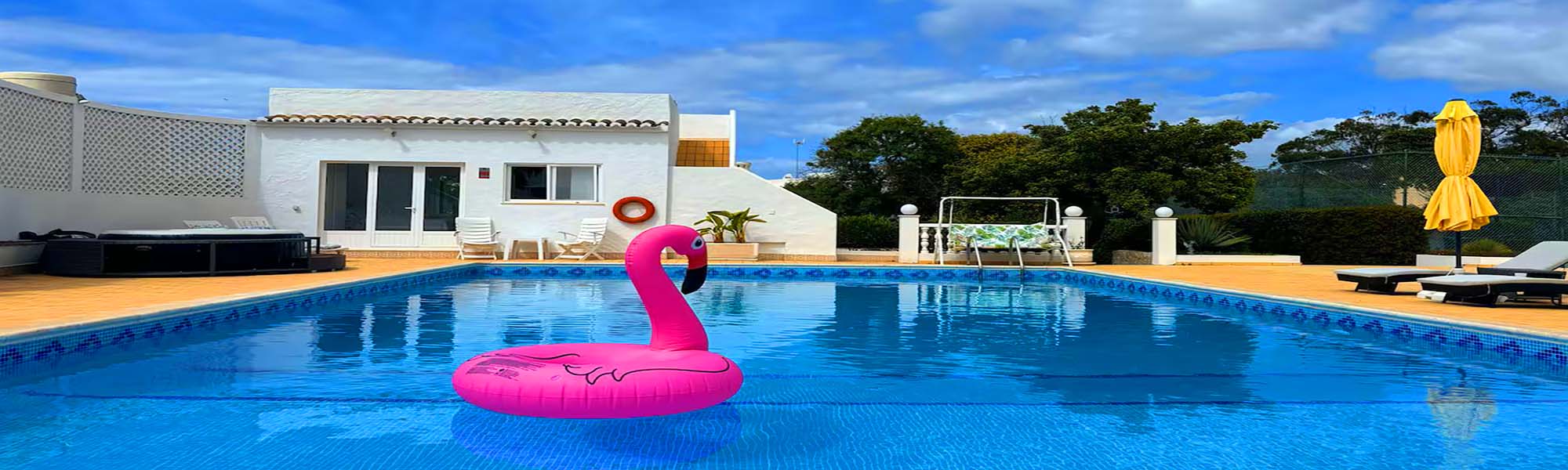Pool with flamingo float and garden views