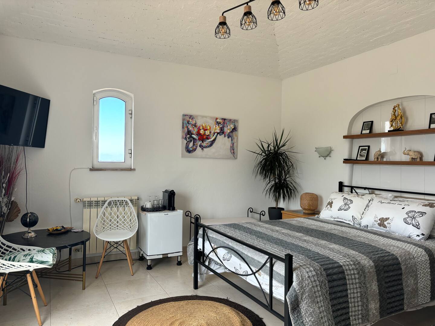 Bright guest bedroom with queen bed and seating