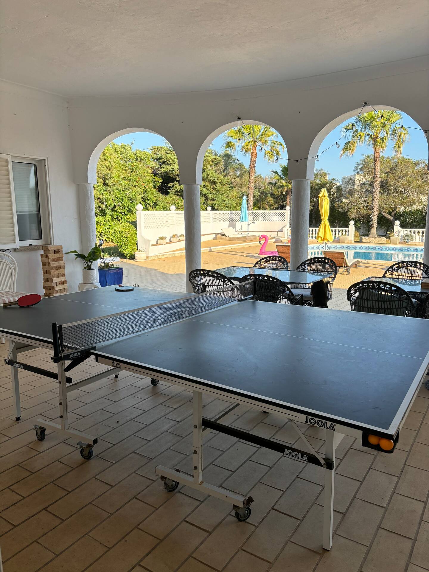 Covered lounge with ping‑pong overlooking pool